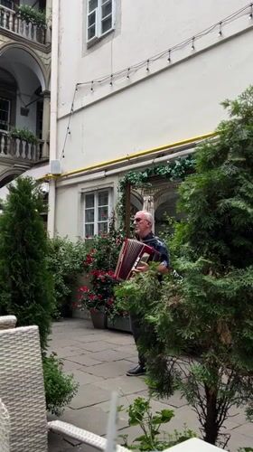 Live music and lunch crowd fill a Lviv Renaissance courtyard cafe