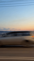 Vehicle crosses bridge in Krasnoyarsk during twilight hours