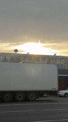 Commercial truck passes through Tashkent as birds circle overhead