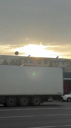 Commercial truck passes through Tashkent as birds circle overhead