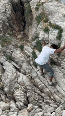 Man descends rocky cliff face in Budva, Montenegro