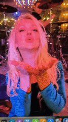 Live stage performance in teal velvet, backed by a band