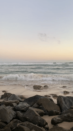 Waves crash on rocky Kathaluwa beach at sunset