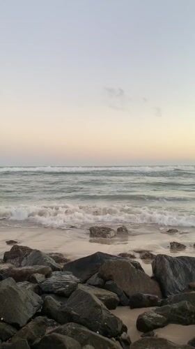 Waves crash on rocky Kathaluwa beach at sunset