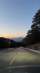 Vehicle travels mountain road at dusk in Fethiye, Turkey