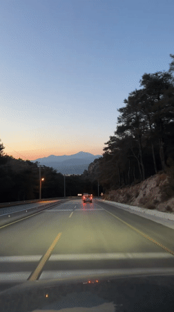Vehicle travels mountain road at dusk in Fethiye, Turkey