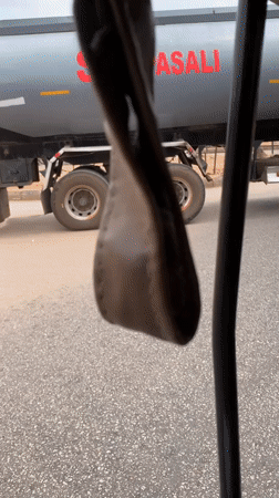 Yellow three-wheeler travels with tanker truck in Bukuru
