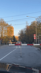 Train crosses intersection in Riga, vehicle waits at barrier
