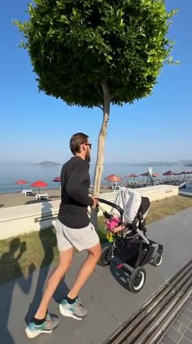 Man runs with baby stroller in Fethiye, Turkey
