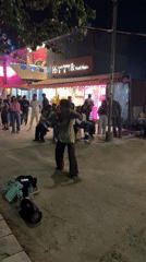 Street dancer performs for crowd outside Pokhara food store