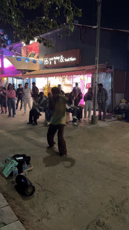 Street dancer performs for crowd outside Pokhara food store
