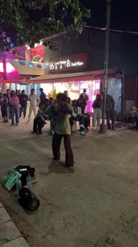 Street dancer performs for crowd outside Pokhara food store