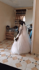 Bride in white gown captured during wedding preparations indoors