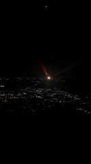 Night aerial view captures crescent moon over San Giuliano Milanese
