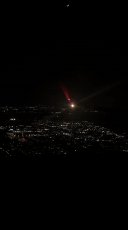 Night aerial view captures crescent moon over San Giuliano Milanese
