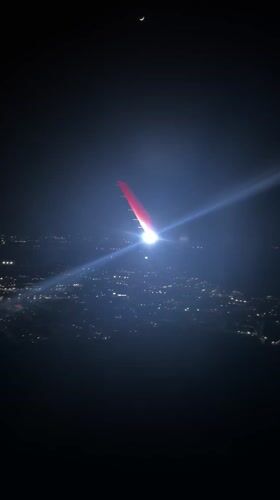 Night aerial view captures crescent moon over San Giuliano Milanese
