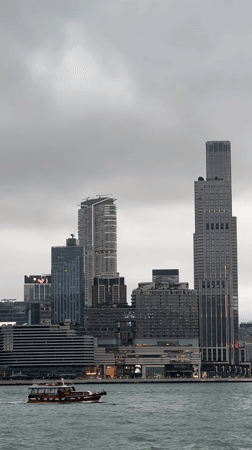 Hong Kong harbor and elevated road traffic captured under gray skies