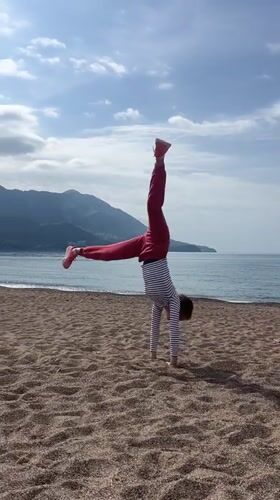 Woman performs beach gymnastics in Montenegro morning hours