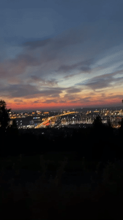 Dusk city views from a hilltop viewpoint, helmet and all