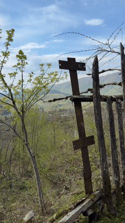 Rural landscape with weathered fence, cross documented in Vakhani