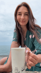 Woman enjoys morning drink on Sochi beach