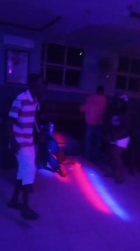 Nightclub patrons dance under colorful lights in Lokoja, Nigeria