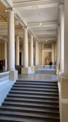 Visitor documents classical museum interior with columns and artwork