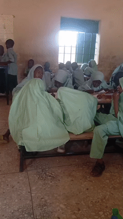 Students in matching uniforms attend a classroom lesson together