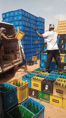 Men unload empty beer bottles at distribution facility