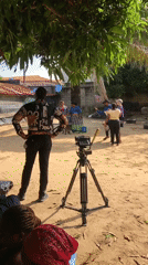 Outdoor video shoot in progress at a sandy residential location