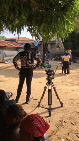 Outdoor video shoot in progress at a sandy residential location