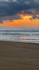 Sunset over Mylestom beach, clouds glowing orange and pink