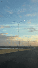 Vehicle travels empty highway in Guayana City dawn light