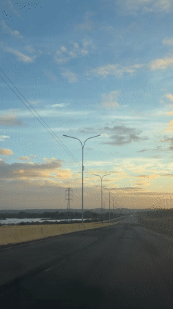 Vehicle travels empty highway in Guayana City dawn light