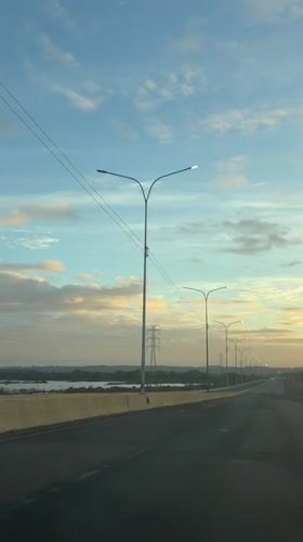 Vehicle travels empty highway in Guayana City dawn light