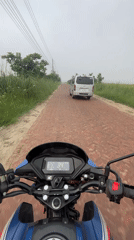 Motorcycle rider navigates brick road in Panchkhola, Bangladesh