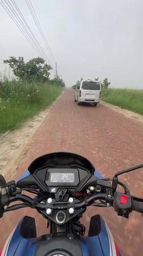 Motorcycle rider navigates brick road in Panchkhola, Bangladesh
