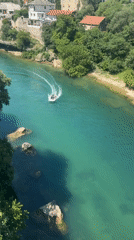 Boat travels Neretva River near historic Stari Most bridge