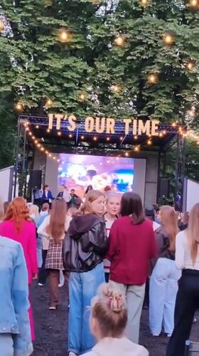 Outdoor stage event in Minsk with 'It's Our Time' signage