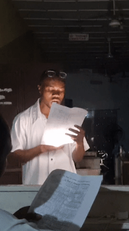 Evening indoor gathering in Lagos, reading from papers