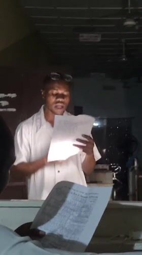 Evening indoor gathering in Lagos, reading from papers