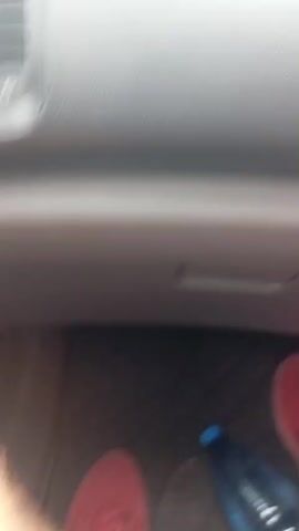 The video shows a view from inside a car driving down a road. The dashboard is visible in the foreground. Outside the car, other vehicles are on the road, and there are trees and buildings lining the street. There is a small building with "ДПС" written on it, which appears to be some sort of checkpoint or office. The sky is overcast. The camera appears to be mounted on the dashboard or windshield.