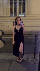 Woman takes nighttime selfies outside Paris storefronts