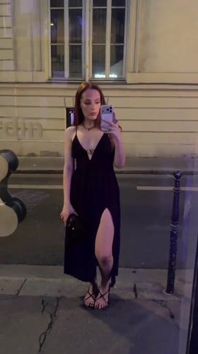 Woman takes nighttime selfies outside Paris storefronts