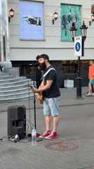 Acoustic street performance on a Kazan sidewalk, summer 2026.