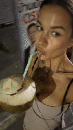Woman enjoys coconut drink, visits night market in Thailand