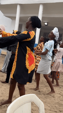Women and children dance barefoot in Badagry, Nigeria