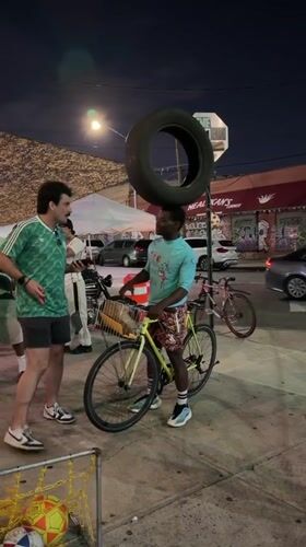 Balancing a tire on a head next to a NYC cab