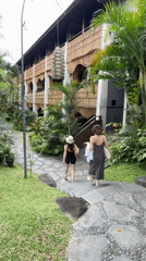 Woman performs early morning yoga backbend on Ubud balcony