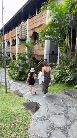 Woman performs early morning yoga backbend on Ubud balcony